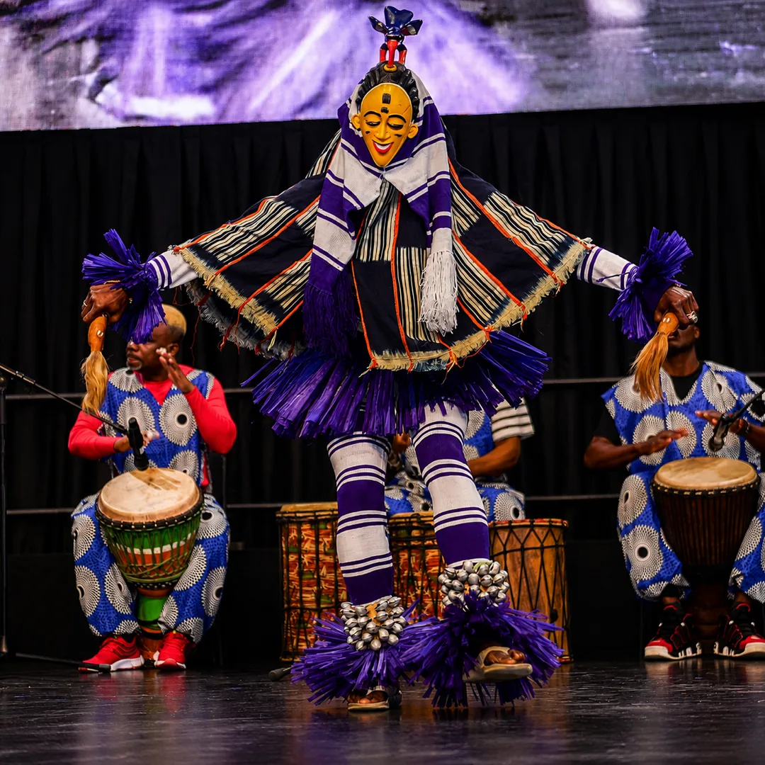 Danseur Zaouli masqué et percussionnistes au djembé sur scène — spectacle de danse africaine